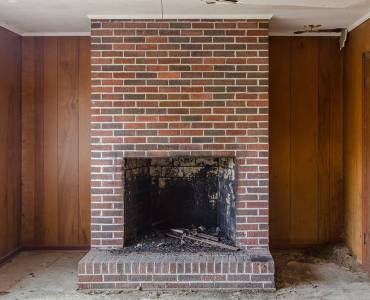 A vintage brick fireplace in an empty room