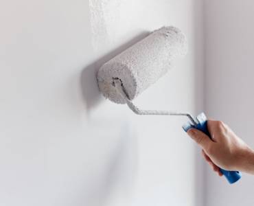 Someone painting a white wall