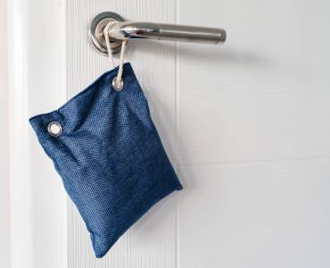 Close up on air purify bag charcoal activated carbon moisture absorber and odor eliminator hanging on the door in apartment 