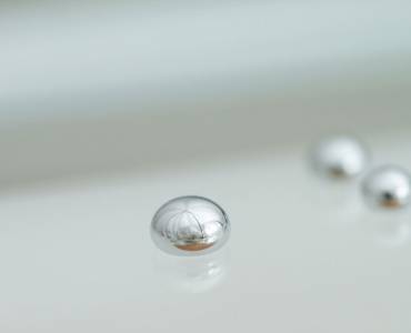 Beads of mercury on a white surface