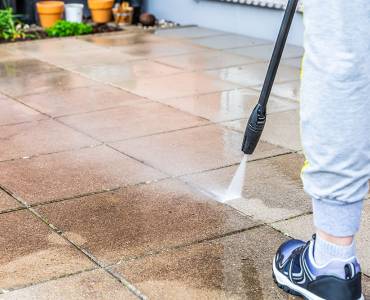 Someone pressure washing their garden stone terrace