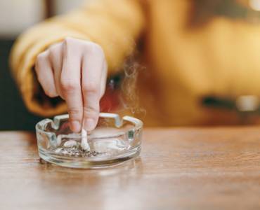 Someone putting a cigarette out in an ashtray