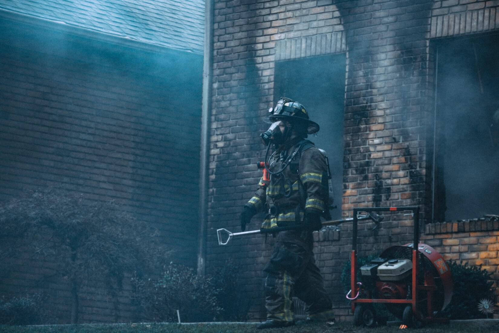 Firefighter outside fire damaged property