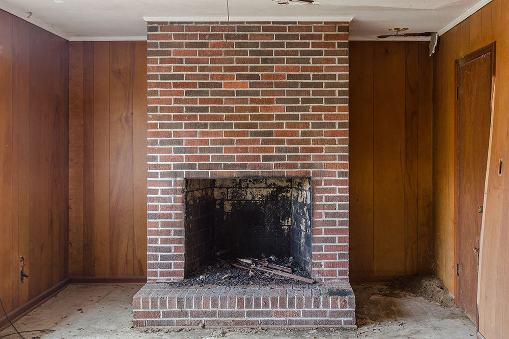 A vintage brick fireplace in an empty room