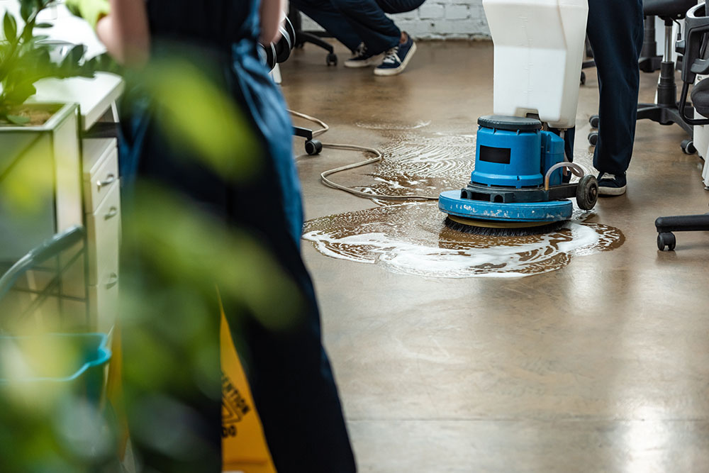 A cleaner using an industrial machine to clean an office floor