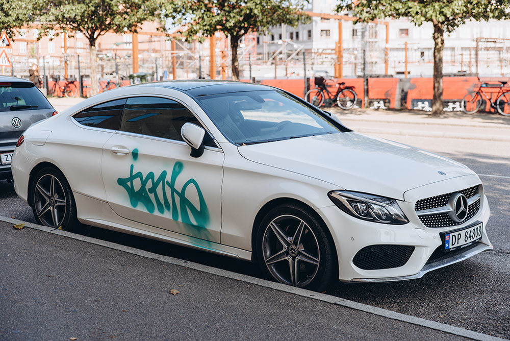 Green graffiti sprayed onto a white vehicle