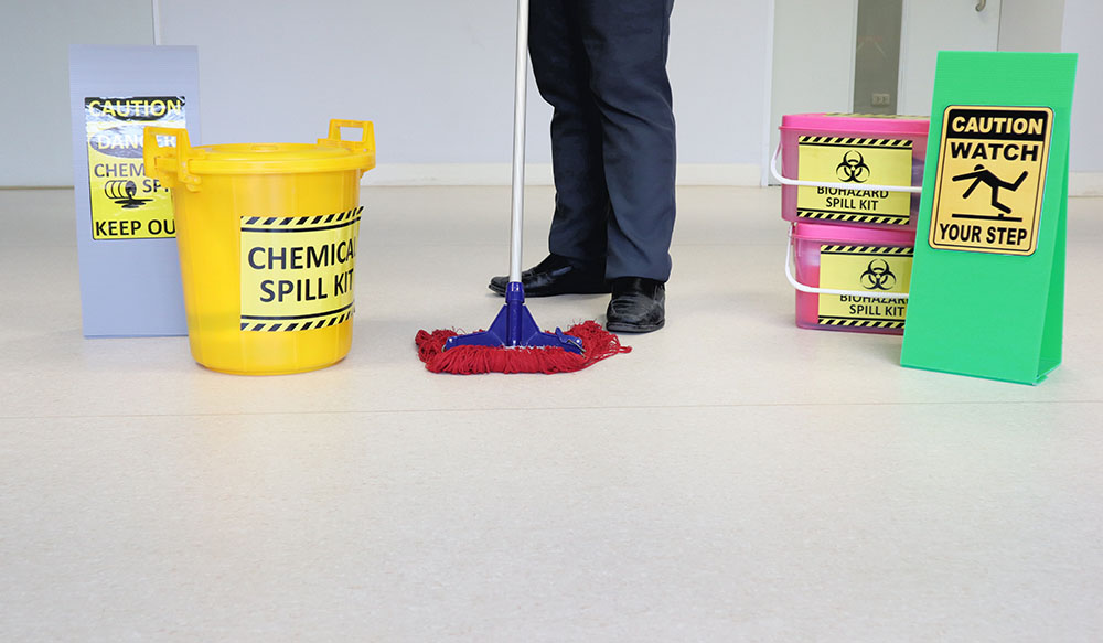 Someone cleaning up a chemical spill with chemical spill equipment