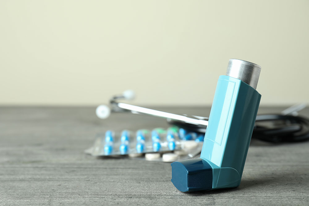 An asthma pump and allergy medication on a table