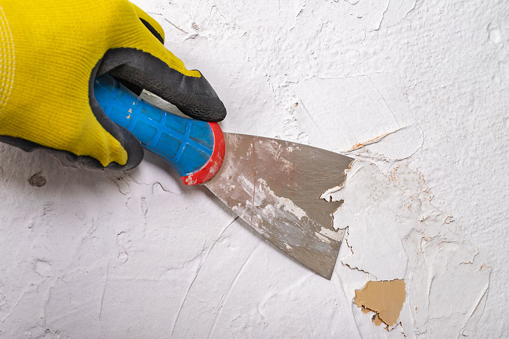 Paint being removed with a scraper