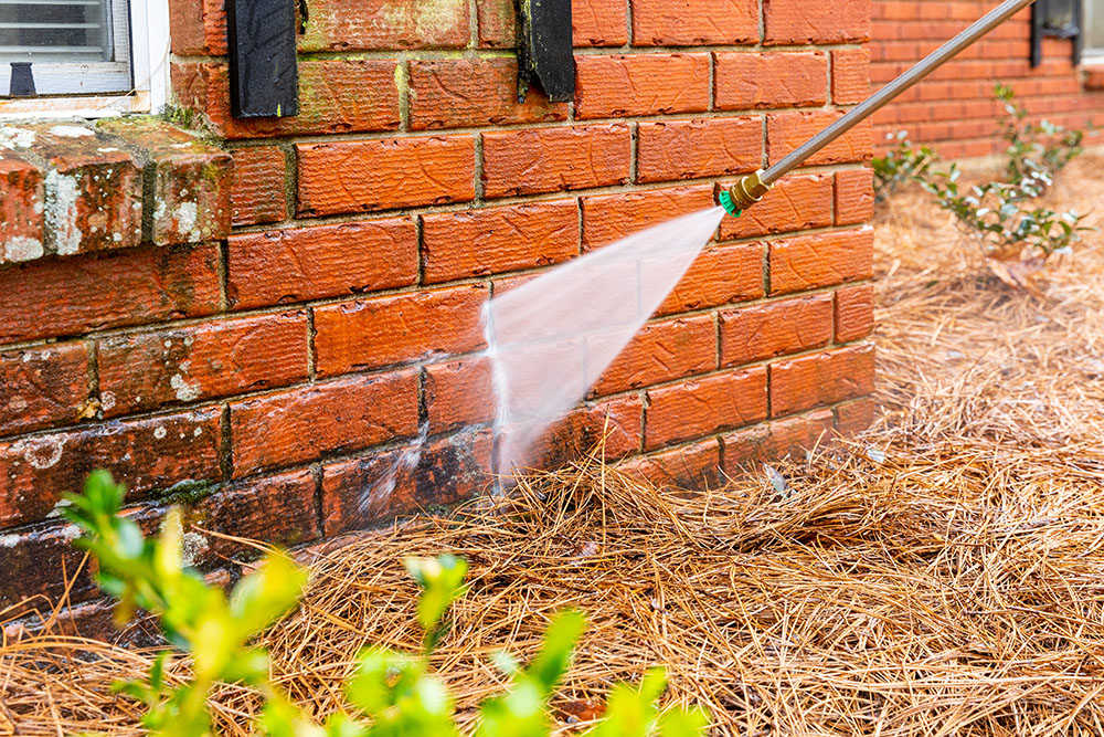 Pressure washer on brick house