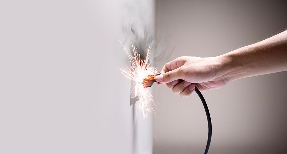 A plug sparking at the outlet as it is plugged in