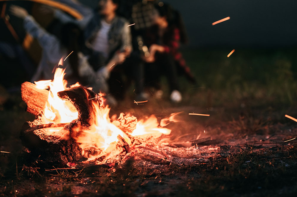 People sitting around a small open fire