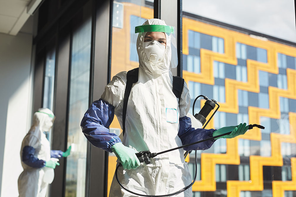 A trauma cleaner standing by a window with a fogging device