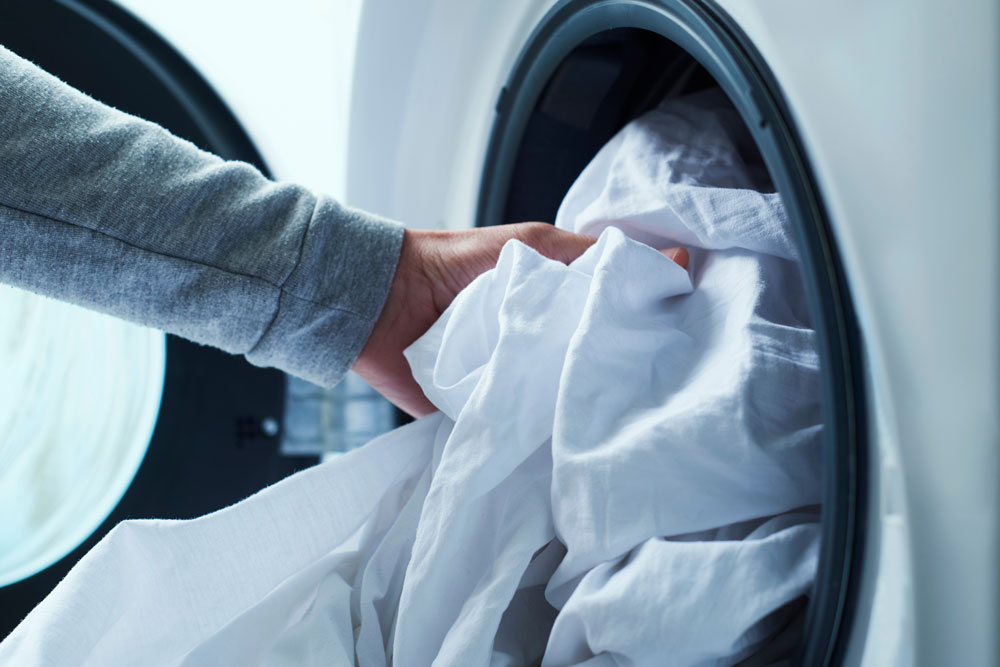 Someone taking clothes out of a washing machine