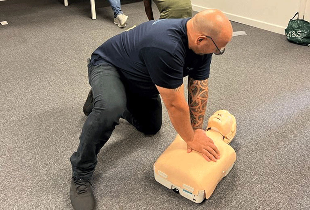 Someone performing CPR on a doll