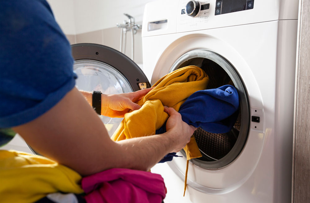 Someone taking clothes out of a washing machine