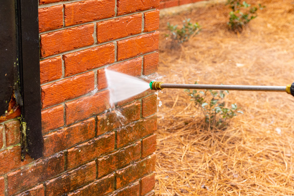 Someone power washing bricks