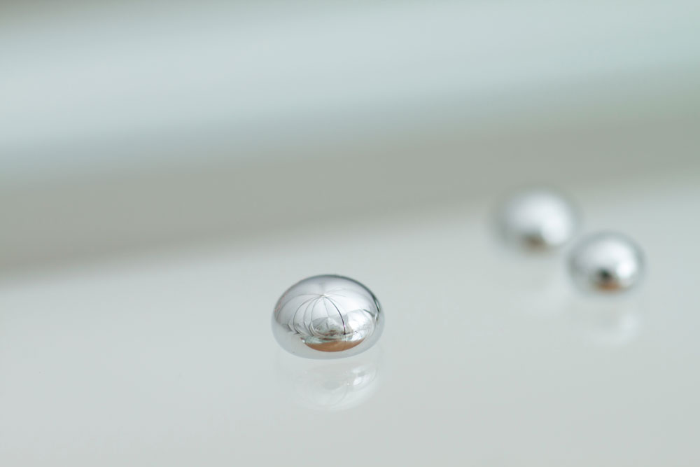 Beads of mercury on a white surface