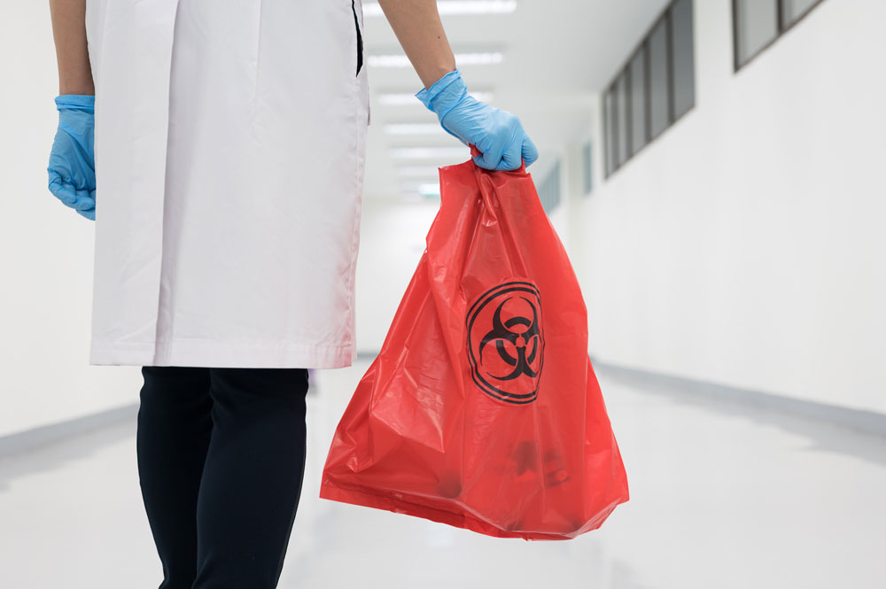 Someone carrying a biohazard disposal bag