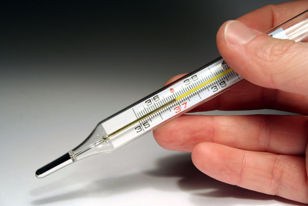 Someone holding a mercury thermometer