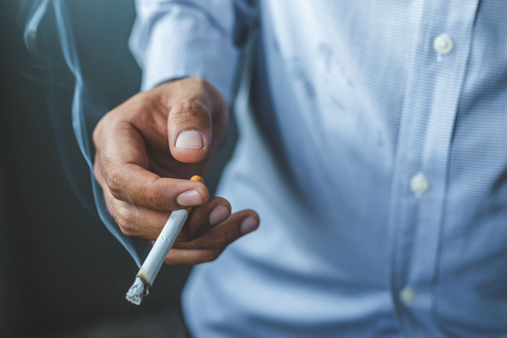 A man holding a lit cigarette