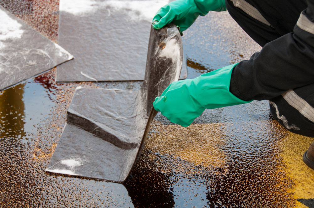 Oil spill on tarmac being cleaned up