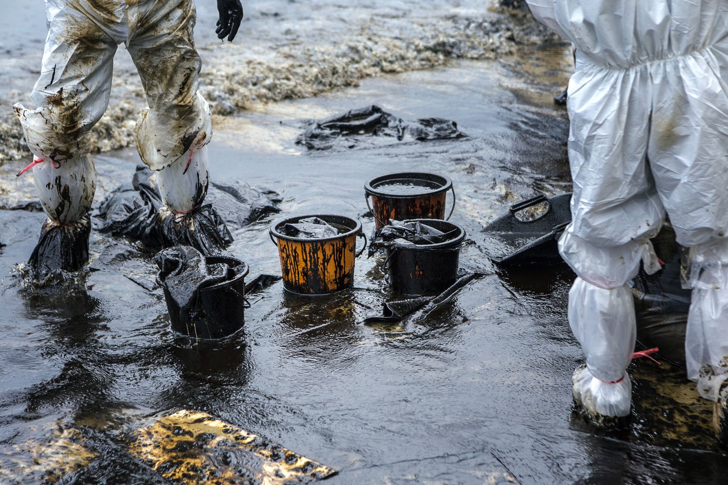 Two people in PPE during oil spill cleanup