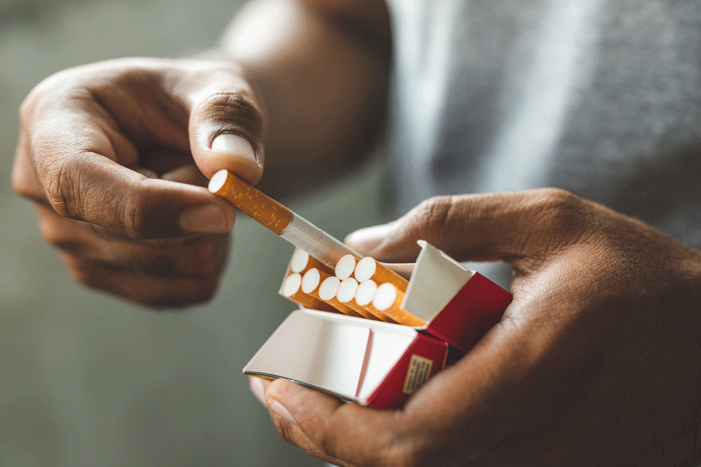 Someone taking a cigarette out of a pack