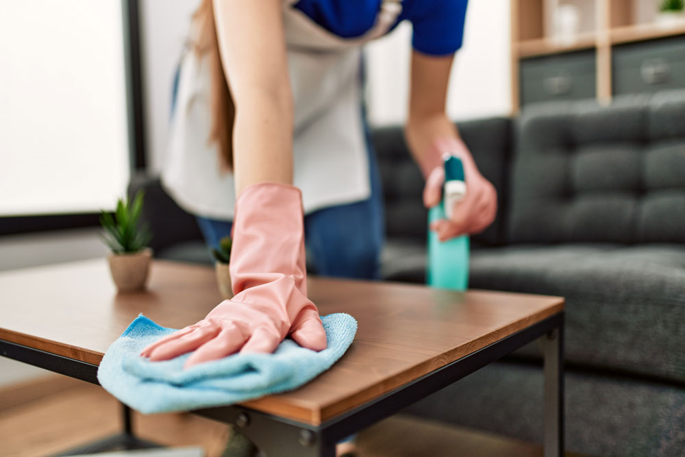 Cleaner wiping down a table