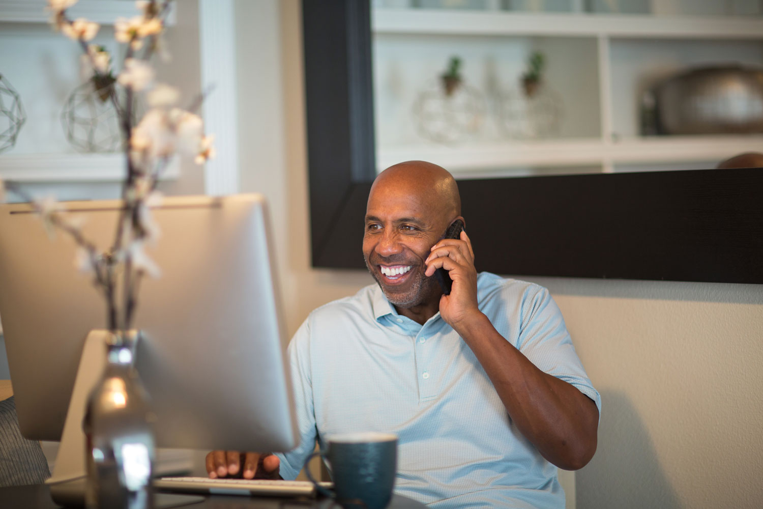 Man smiling whilst on the phone from his home office