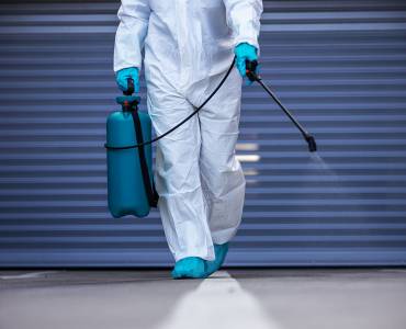A trauma cleaner sanitising a floor